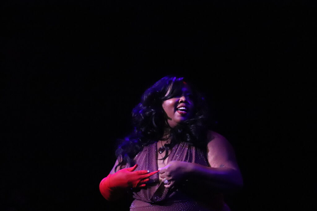 Burlesque performer Veronika Raquel Hazard begins to remove a red glove during her performance.